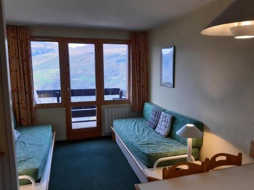 un salon avec un canapé et une grande fenêtre dans l'établissement Résidence Le Sextant - maeva Home - Appartement 2 pièces 5 personnes - Sélection MAE-9811, à La Plagne Tarentaise