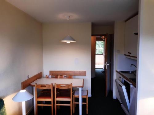 une cuisine avec une table et des chaises dans une pièce dans l'établissement Résidence Le Sextant - maeva Home - Appartement 2 pièces 5 personnes - Sélection MAE-9811, à La Plagne Tarentaise