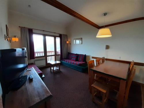 un salon avec une table et un canapé dans l'établissement Résidence La Marelle et Le Rami - maeva Home - Appartement 3 pièces 7 personnes - Confort MAE-5701, à La Plagne Tarentaise