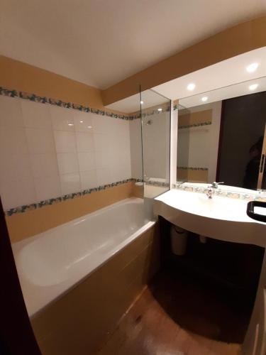 une salle de bain avec une baignoire et un lavabo dans l'établissement Résidence La Marelle et Le Rami - maeva Home - Appartement 3 pièces 7 personnes - Confort MAE-5701, à La Plagne Tarentaise