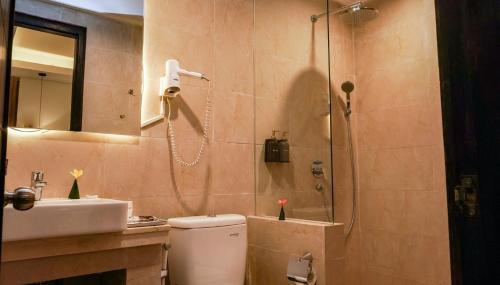 a bathroom with a shower and a toilet and a sink at Grand Sunshine Resort & Convention in Bandung