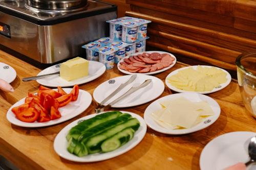 a table with plates of vegetables and cheese at Taj Palace Hotel in Dushanbe