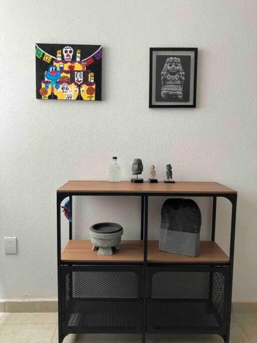 a room with a table with a shelf and a painting at Departamento en Pátzcuaro in Pátzcuaro