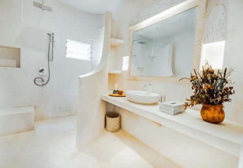 a white bathroom with a sink and a mirror at Casa Zuri Diani Beach Villa in Diani Beach