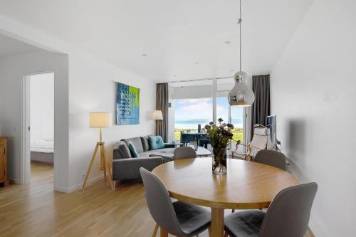 a living room with a table and a couch at Beautiful Holiday Apartment With A View Of Ebeltoft Vig And Walking Distance To The Town Center in Ebeltoft