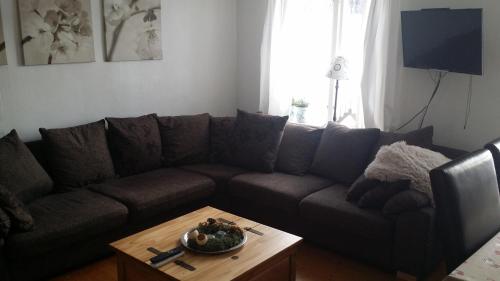 a living room with a brown couch and a table at Stuga Gruvriset in Fredriksberg