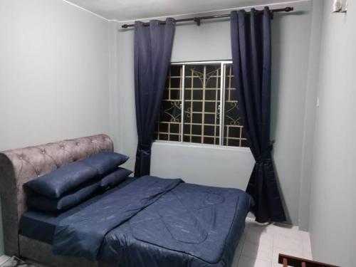 a bedroom with a blue bed and a window at Amara Homestay Cameron Highlands in Cameron Highlands