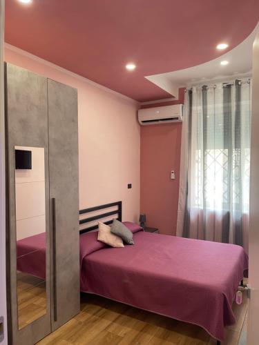 a bedroom with a purple bed and a window at B&B Son De Mar in Salerno