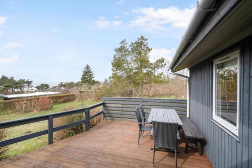 a deck with a table and chairs on a house at Beautiful Home In Knebel With 3 Bedrooms in Knebel