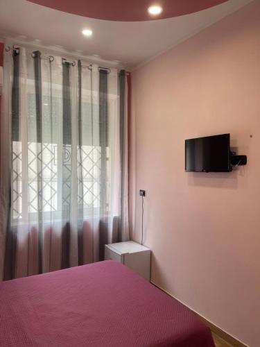 a bedroom with a bed and a tv on the wall at B&B Son De Mar in Salerno