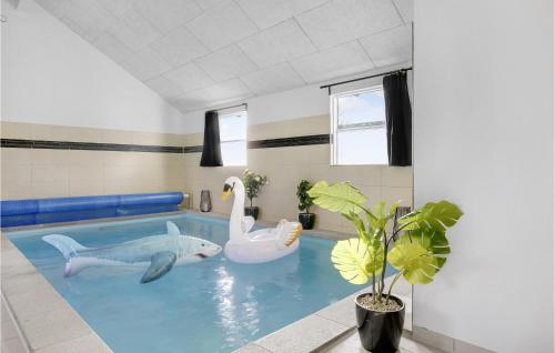 a swimming pool with two inflatable animals in it at Lovely Home In Tisvildeleje With Sauna in Holløselund