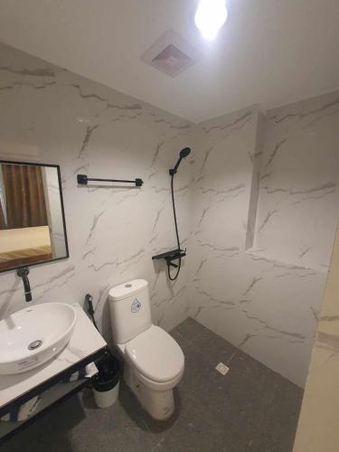 a bathroom with a white toilet and a sink at JMC4 Cozy Room1 Near Alona Beach in Panglao