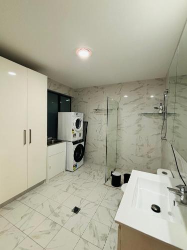 a bathroom with a shower and a sink and a microwave at Family home in Mount Colah
