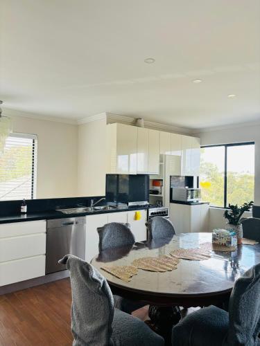 a kitchen with a table and chairs in a room at Family home in Mount Colah