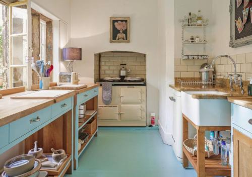 a large kitchen with blue floors and a blue floor at Artisan Hall: 4BD Stunning Grandeur in Cotswolds in Toddington