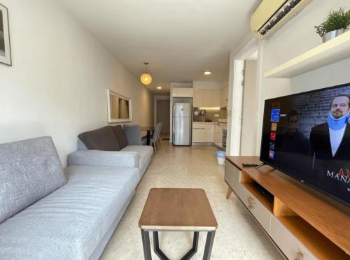 a living room with a couch and a flat screen tv at AXON Residence Kuala Lumpur in Kuala Lumpur