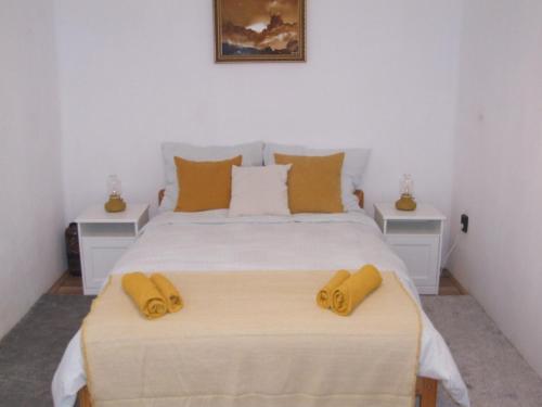 a bedroom with a large white bed with yellow pillows at Simon Vendégház in Badacsonytördemic