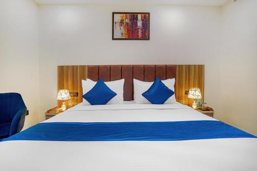 a bedroom with a large bed with blue pillows at HOTEL SKY VIEW - Zirakpur, Chandigarh in Zirakpur