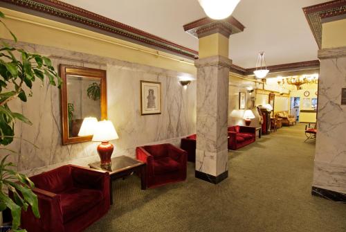 a lobby with red chairs and a table with a lamp at Aida Plaza Hotel in San Francisco