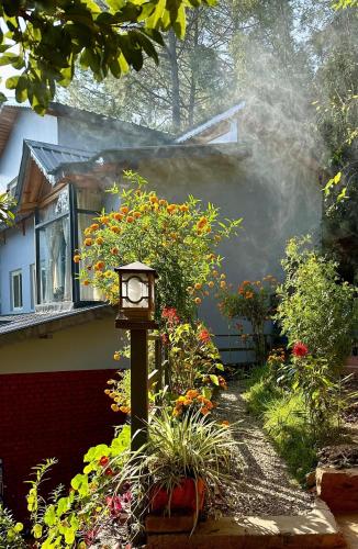 a clock in a garden in front of a house at Oakakhi Stays, Deluxe room in Rānīkhet