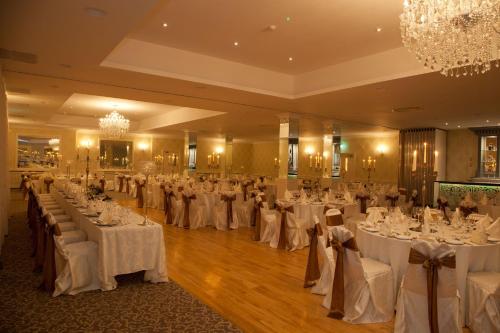 a banquet hall filled with tables with white linens at Clybaun Hotel in Galway