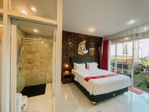 a bedroom with a king sized bed and a shower at Bhuana Agung Villa and Restaurant in Jatiluwih