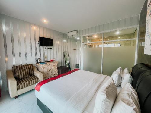 a bedroom with a bed and a couch and a television at Bhuana Agung Villa and Restaurant in Jatiluwih