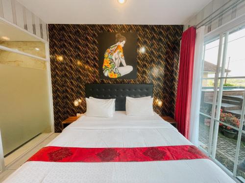 a bedroom with a large white bed with a red blanket at Bhuana Agung Villa and Restaurant in Jatiluwih