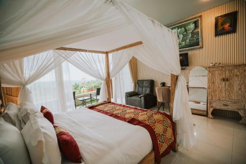 a bedroom with a canopy bed and a chair at Bhuana Agung Villa and Restaurant in Jatiluwih