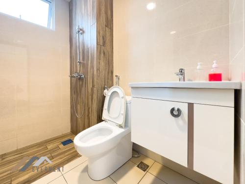 a white bathroom with a toilet and a sink at Serene Heights by Evernent in Miri