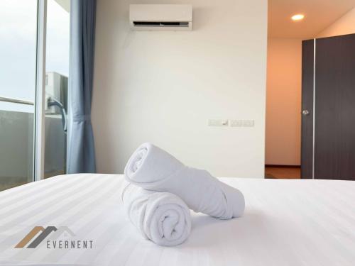 a pile of towels sitting on top of a bed at Serene Heights by Evernent in Miri