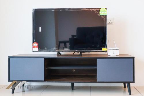 a desk with a tv on top of it at Serene Heights by Evernent in Miri