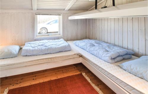 two beds in a small room with a window at Holiday Home Otterup With Sauna 302 in Otterup