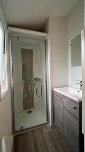 une salle de bain avec douche et lavabo dans l'établissement Mobil-home 316 3 chambres domaine de la forge 4 étoiles bassin arcachon, à La Teste-de-Buch