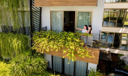 two women standing on the balcony of a house at Bellerive Hoi An Resort and Spa in Hoi An