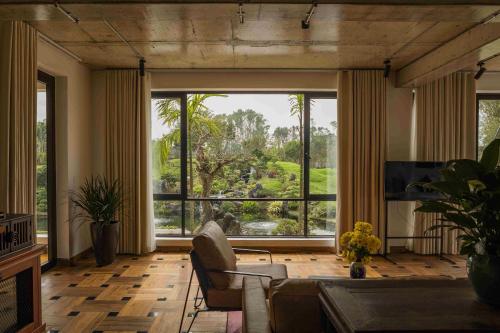 a living room with a couch and a large window at aNhill Boutique in Hue