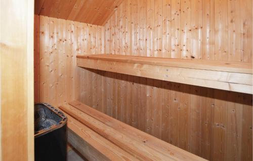 a wooden sauna with wooden shelves and a trash can at Søhøjlandet in Gjern