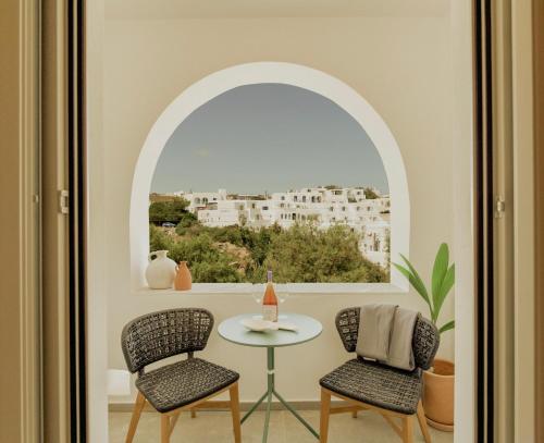 a room with a table and two chairs and a window at Opal Paros in Naousa