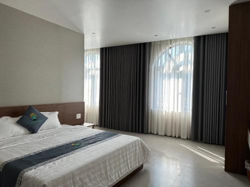 a bedroom with a bed and a large window at Eco Homestay Cát Bà in Cat Ba