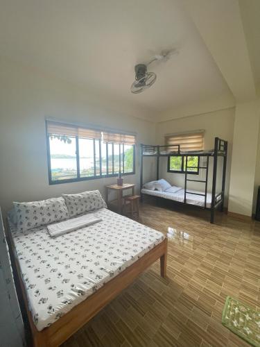 a bedroom with a bed and a bunk bed at Pamasyar Transient Inn in Romblon