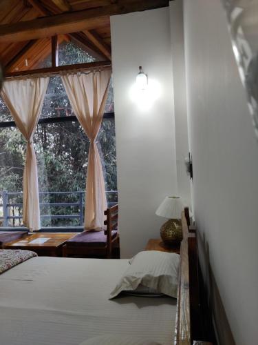 a bedroom with a bed and a window at Oakakhi Stays, Deluxe room in Rānīkhet