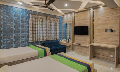 a bedroom with two beds and a tv at Treebo Orion Sapphire, Beck Bagan in Kolkata