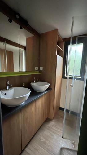 une salle de bain avec deux lavabos et un miroir dans l'établissement chalet 315 camping 4 étoiles Bassin d'Arcachon La Teste, à La Teste-de-Buch