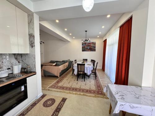 a kitchen and a living room with a table at Harmony Lake House in Chon-Sary-Oy