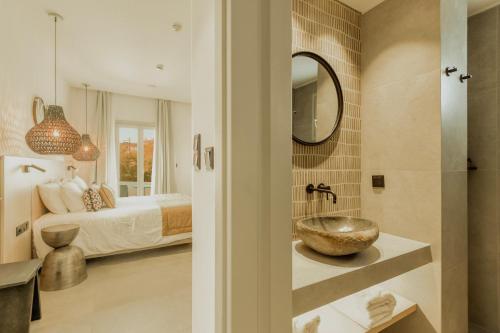 a bathroom with a sink and a bedroom with a bed at Opal Paros in Naousa