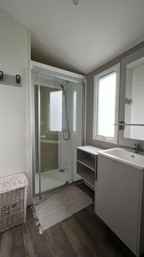 une salle de bain avec une douche, un lavabo et un miroir dans l'établissement Mobil Home 220 aménagé 2 chambres la teste camping 4 etoiles, à La Teste-de-Buch
