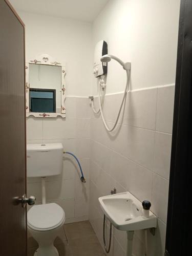 a bathroom with a white toilet and a sink at Hotel Seri Intan Tampin in Tampin