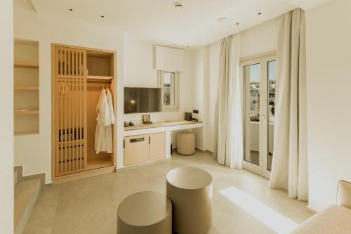 a white kitchen with two stools and a counter at Opal Paros in Naousa