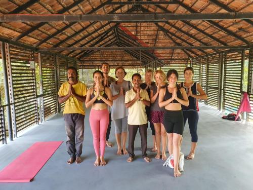 a group of people doing yoga in a building at Palm Paradise Home Stay in Varkala