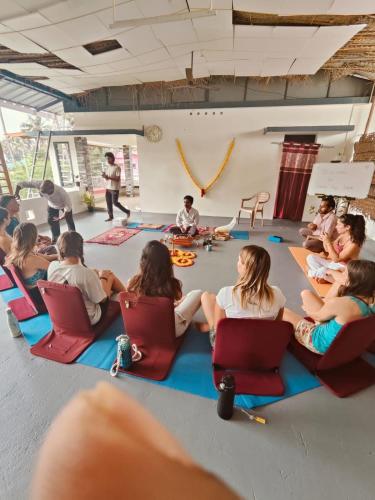 a group of people sitting in chairs in a room at Palm Paradise Home Stay in Varkala